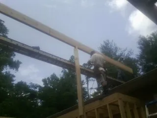 Carpenter setting a ridge beam over a new addition frame — Ice Dam Removal by Roofing Brothers in Thetford Center