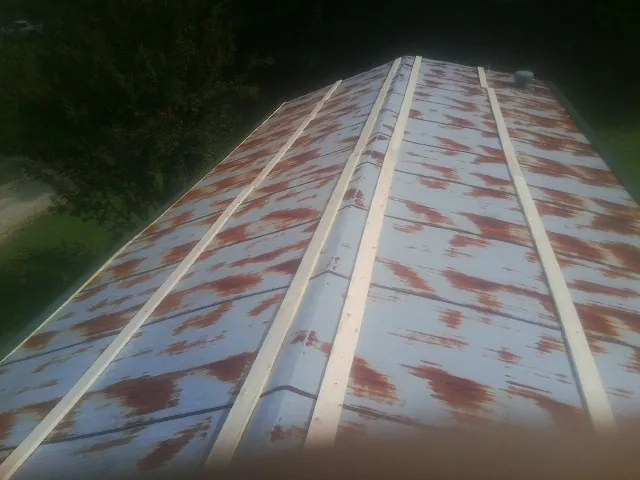 Rusted metal roof panels with new wood purlins before replacement — Storm Damage Roof Repair in Thetford Center by Roofing Brothers